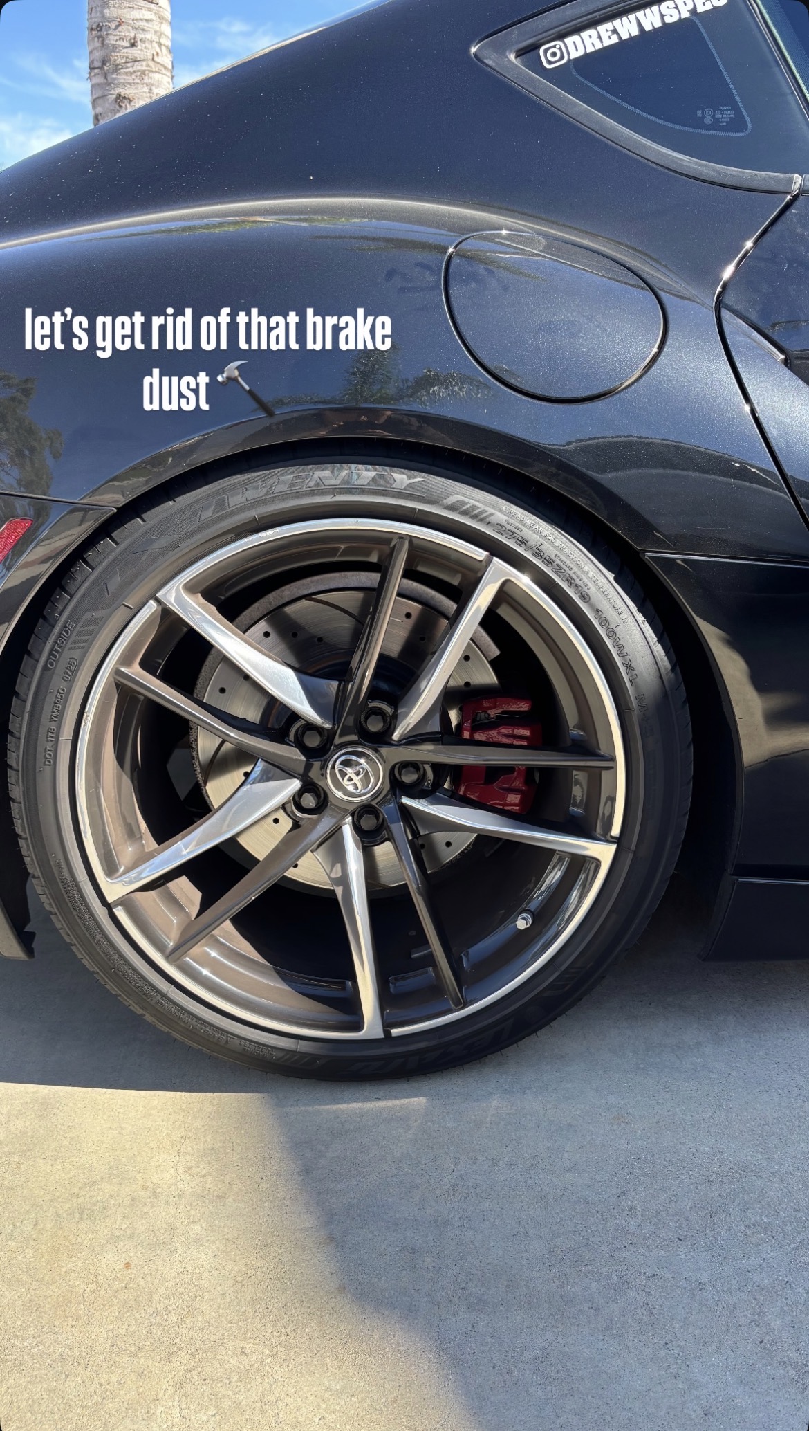 Detailer actively working on wheel — mid-detail process